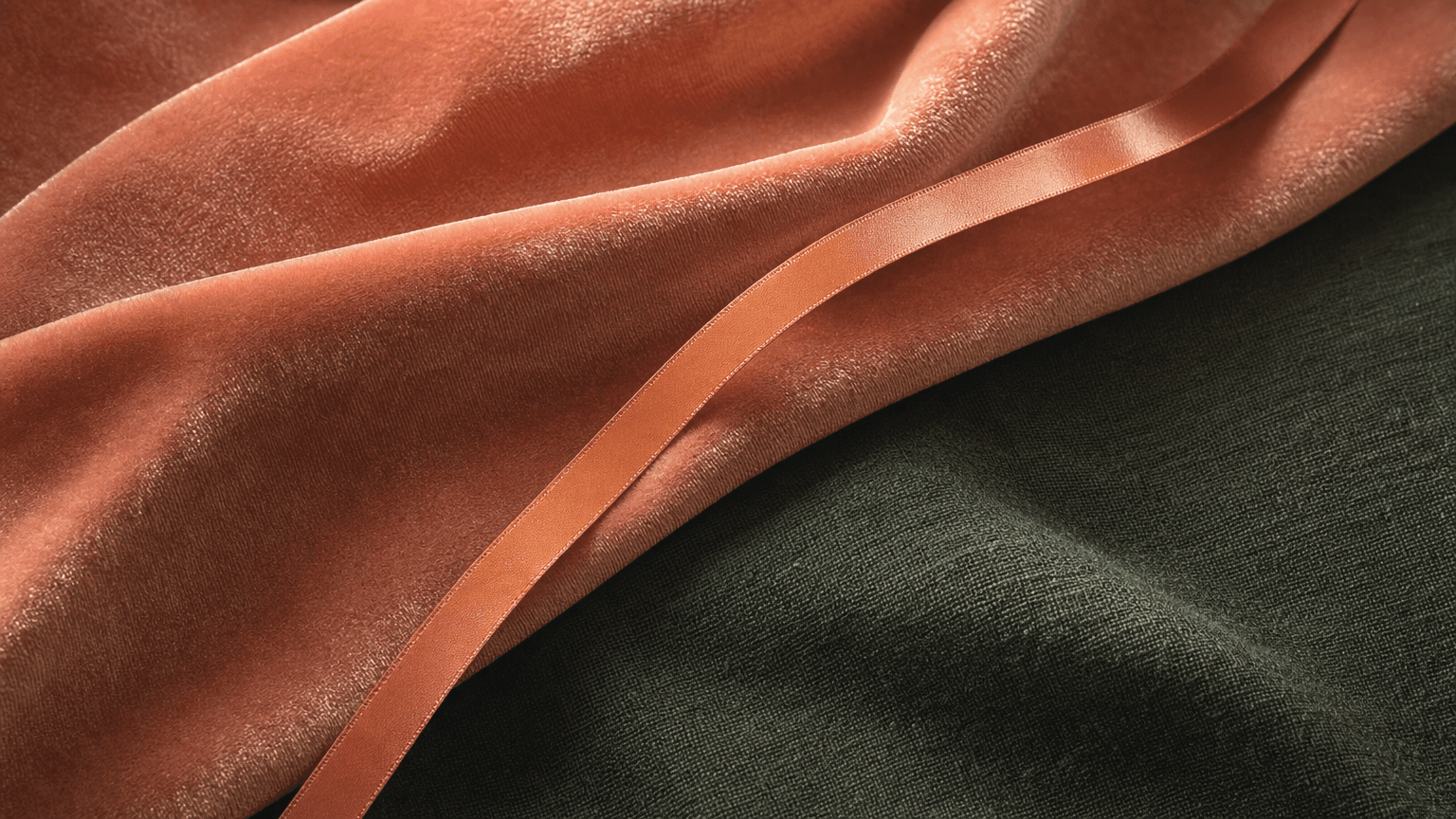 Dusty-coral Samt mit einem feinen peach Satinband, das diagonal aufsteigt — ruhige Recovery-Textur