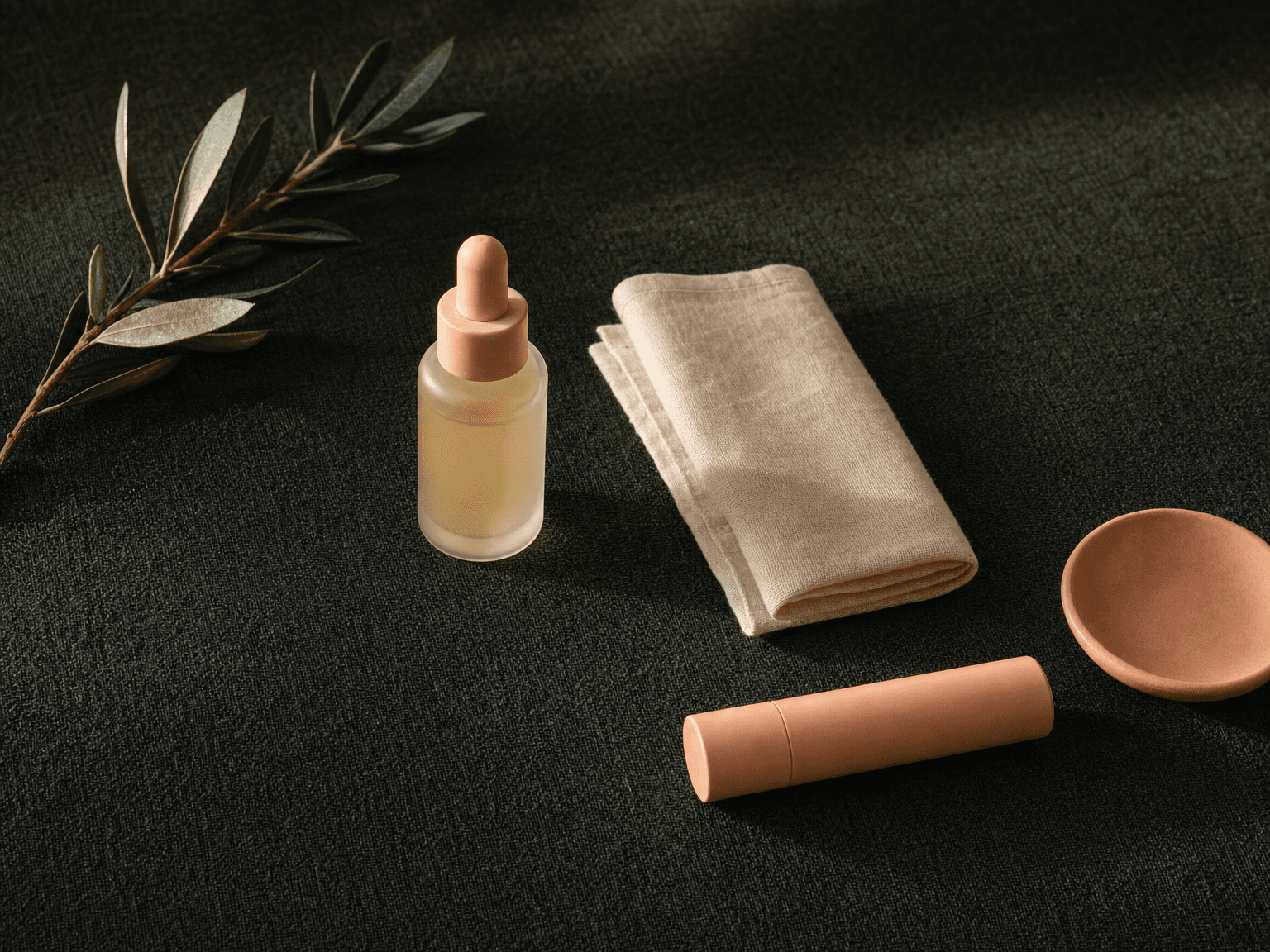 Apotheker-Glasflasche mit antiviraler Medikation, schlanke peach Lippen-Balsam-Hülse, Linentuch und Olivenzweig auf charcoal-grünem Leinen — Stillleben Nachsorge