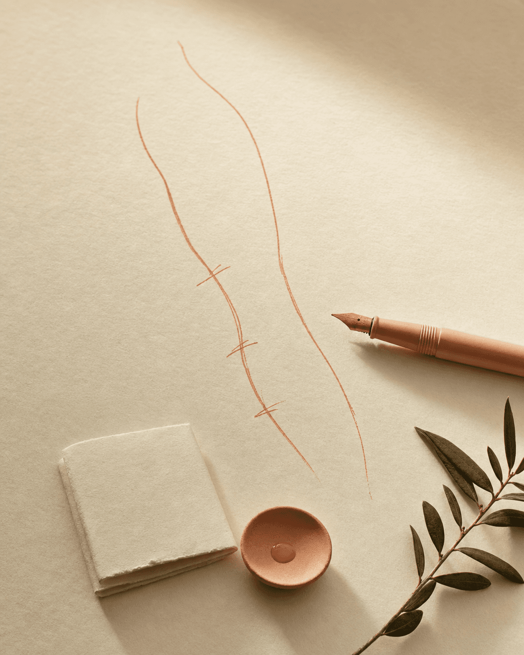 Bone-cream Papier mit handgezeichneter peach Tuschelinie eines Oberschenkel-Konturentwurfs, peach Füller daneben — Stillleben individueller Anzeichnung