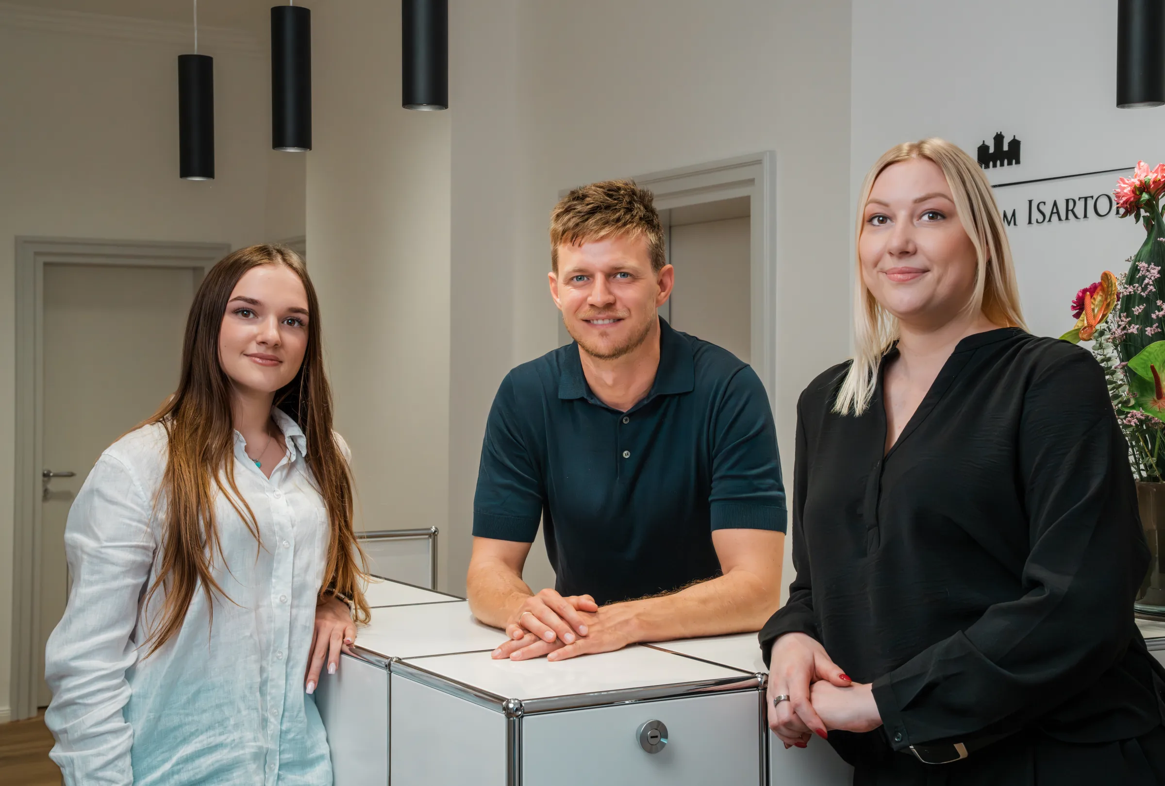 Das Team der Praxis Ästhetik am Isartor München: Dr. Fabian Weinschenk mit Praxismanagerin Jennifer Tiedemann und Medizinischer Fachangestellter Mariia Kan